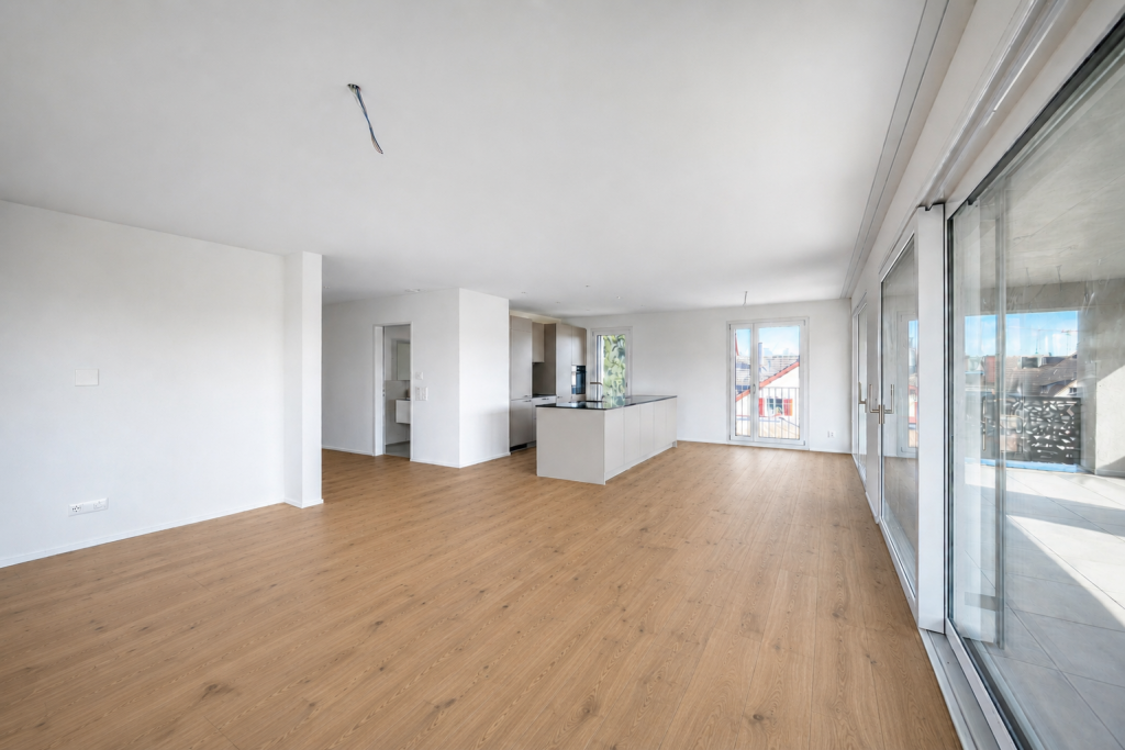 Offener Wohn- und Essbereich mit Kücheninsel, Parkettboden und Schiebetüren zum Balkon, Frontalperspektive.